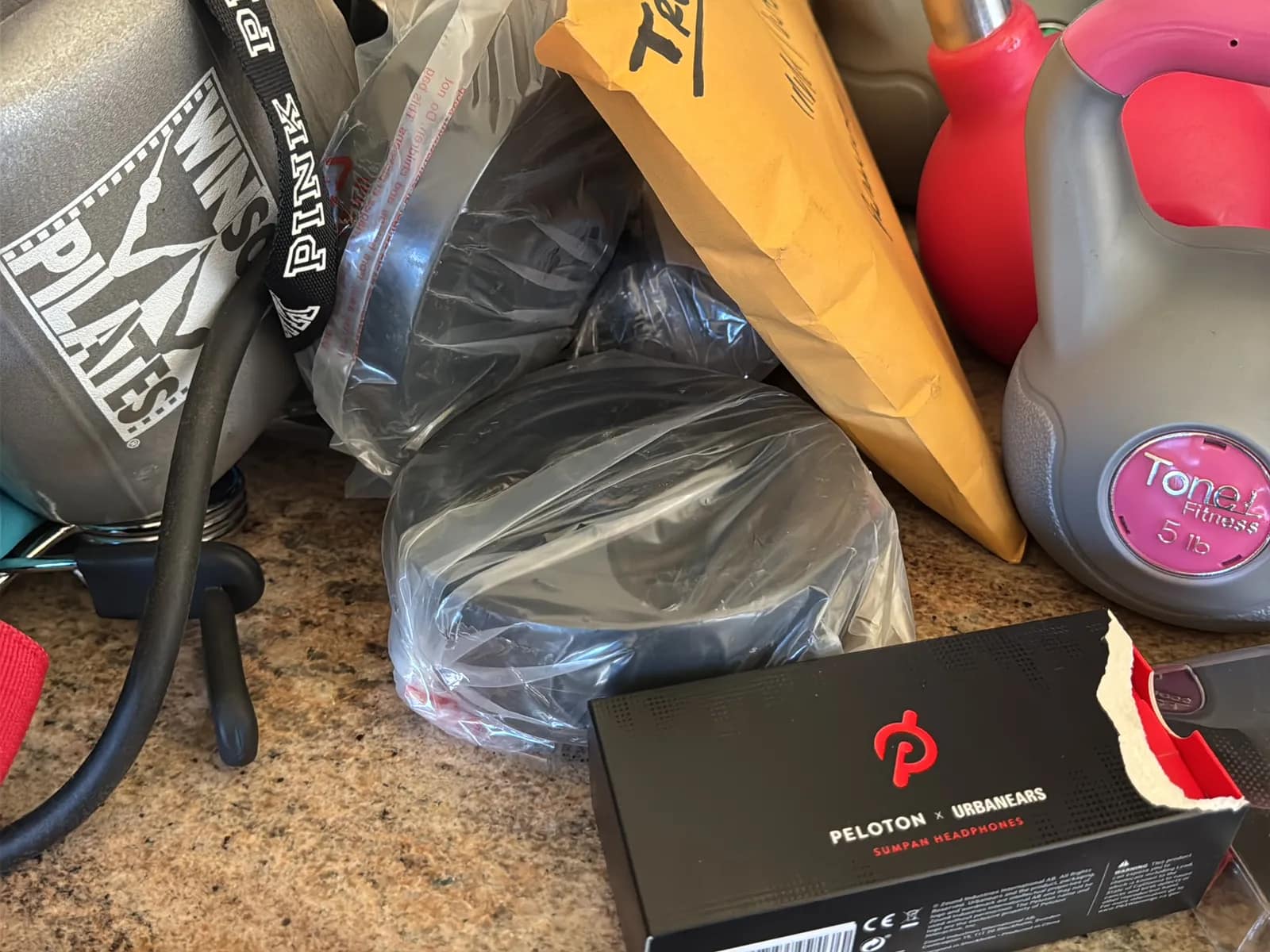 Contents Of Countertop: Kettlebells, Rubber Bands, Peloton Accessories, Yoga Mats, Pilates Equipment, And Machine Parts, photo 6 of 19