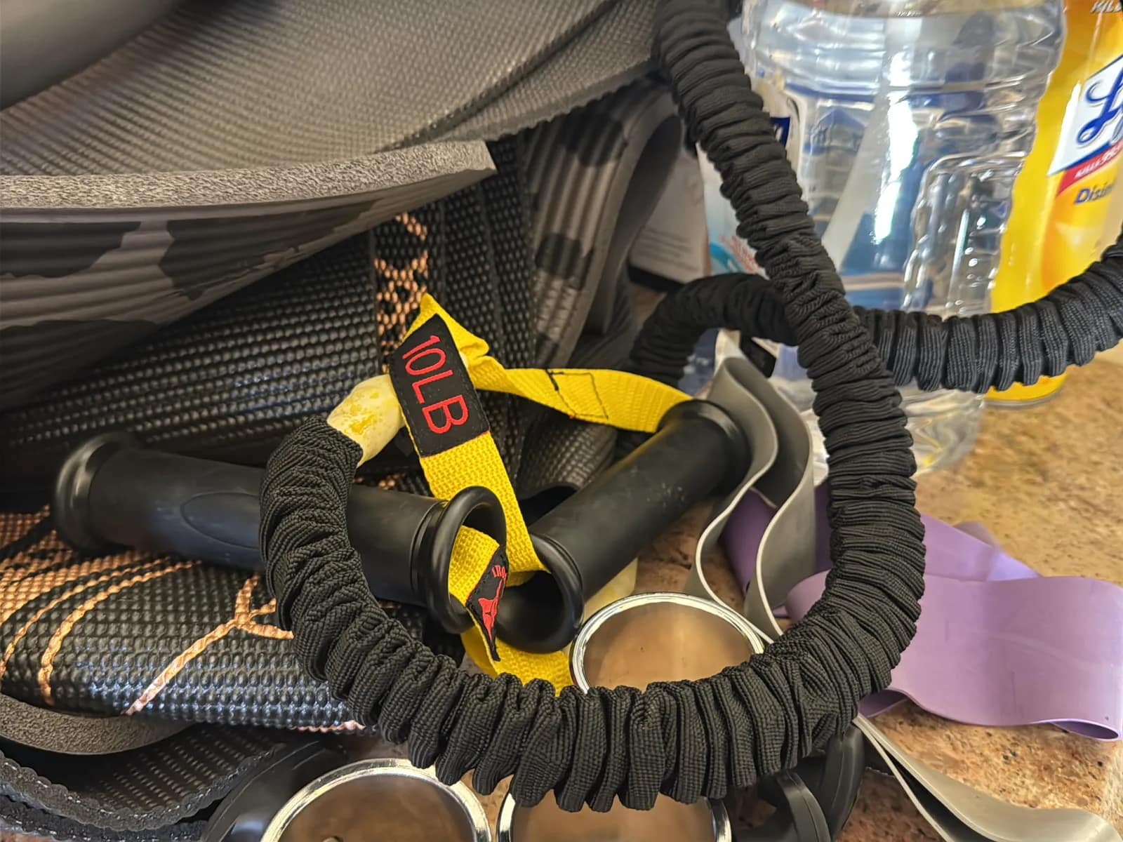 Contents Of Countertop: Kettlebells, Rubber Bands, Peloton Accessories, Yoga Mats, Pilates Equipment, And Machine Parts, photo 15 of 19