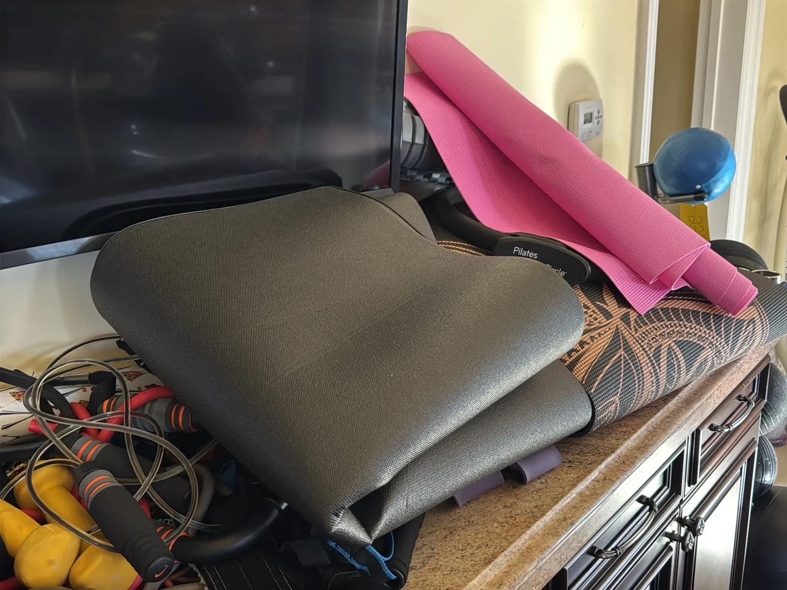 Contents Of Countertop: Kettlebells, Rubber Bands, Peloton Accessories, Yoga Mats, Pilates Equipment, And Machine Parts, photo 11 of 19