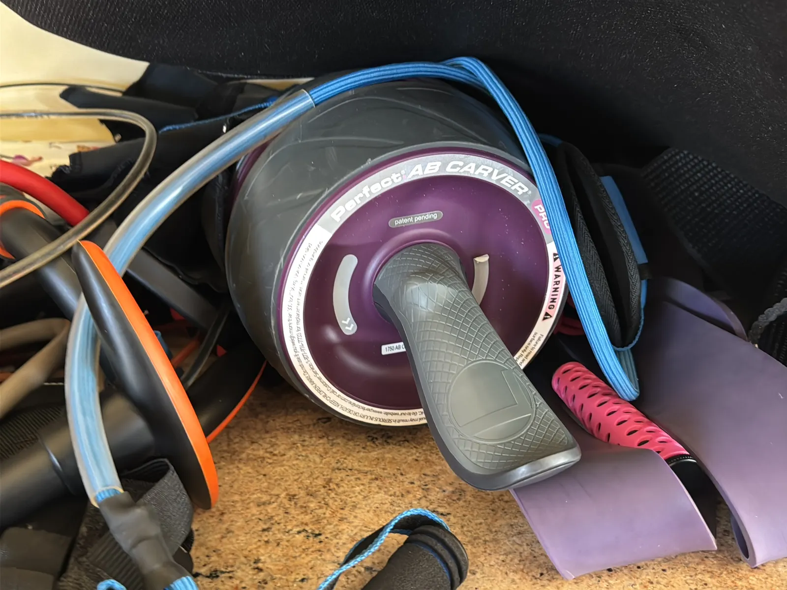 Contents Of Countertop: Kettlebells, Rubber Bands, Peloton Accessories, Yoga Mats, Pilates Equipment, And Machine Parts, photo 17 of 19
