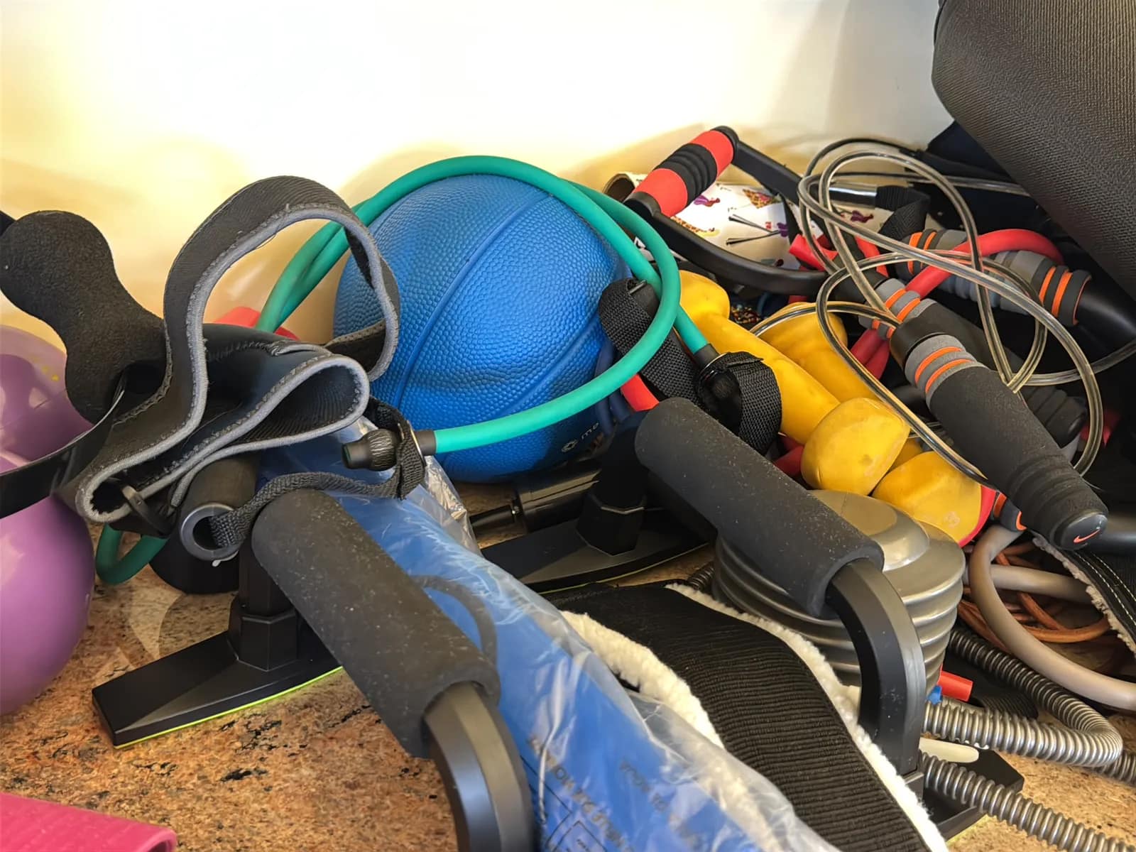 Contents Of Countertop: Kettlebells, Rubber Bands, Peloton Accessories, Yoga Mats, Pilates Equipment, And Machine Parts, photo 8 of 19