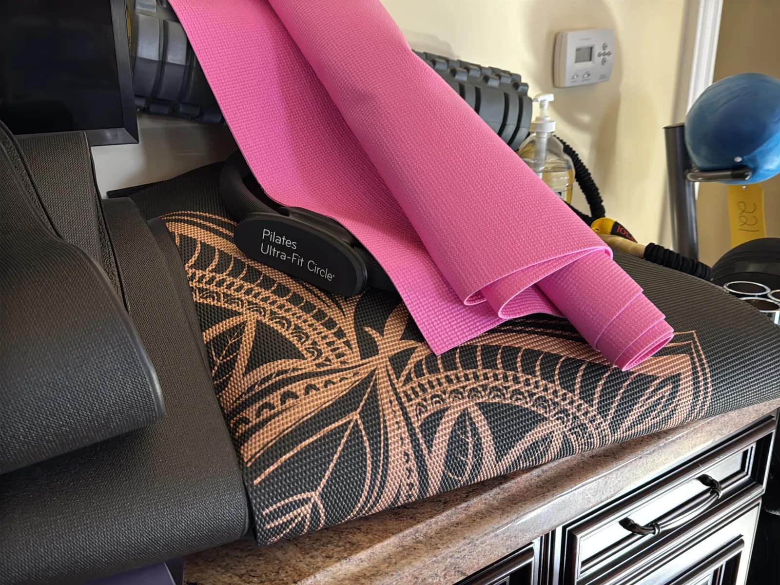Contents Of Countertop: Kettlebells, Rubber Bands, Peloton Accessories, Yoga Mats, Pilates Equipment, And Machine Parts, photo 12 of 19