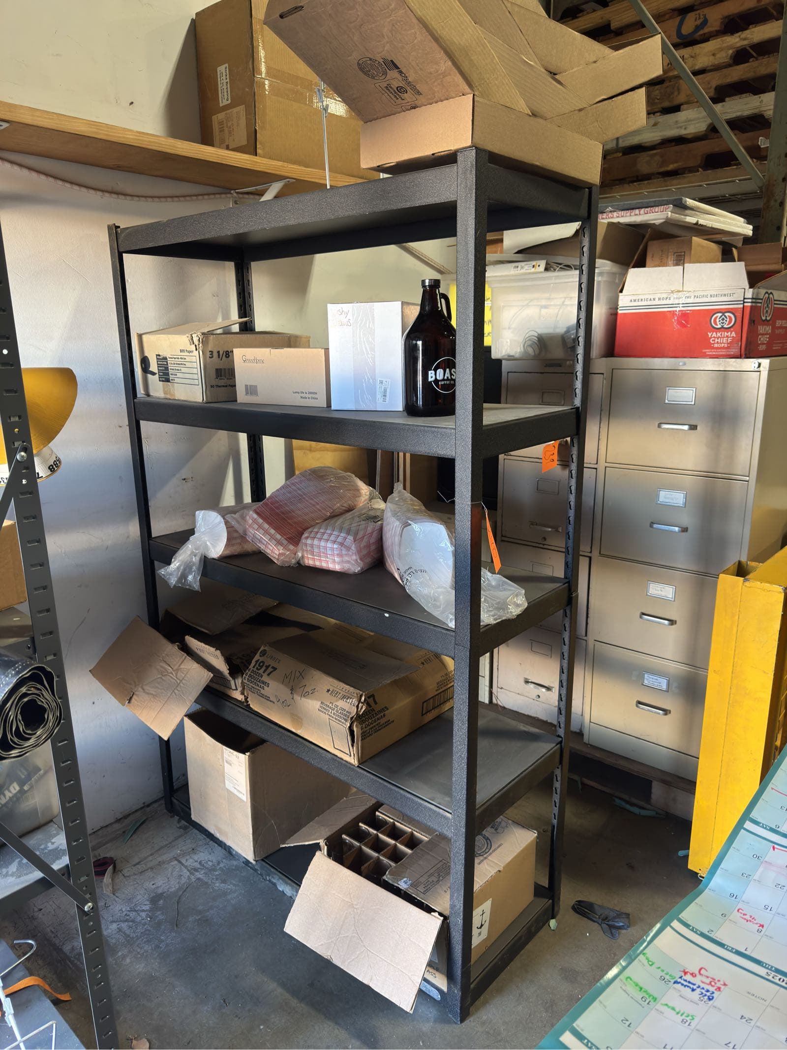 metal-storage-rack-with-contents-boxes-of-flight-glasses-thermal-paper-straws-and-more-606a1c