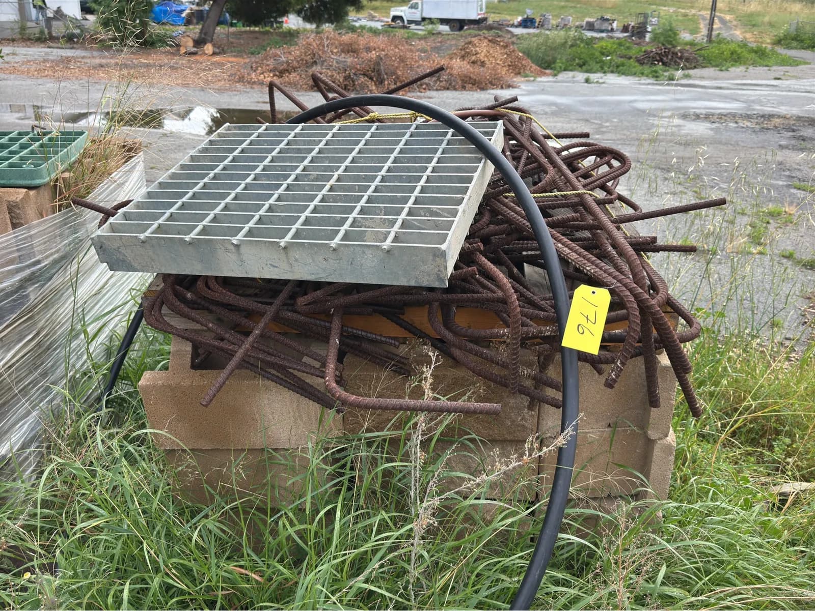 pallet-of-concrete-retaining-wall-blocks-sewer-grate-and-rebar-mnp84oi1