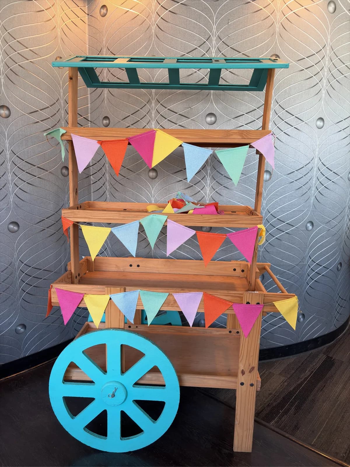 wooden-display-cart-with-wheels-and-colored-penants-c29f47
