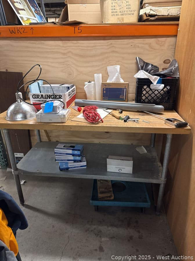 steel-and-wood-table-with-contents-garbage-bags-ppe-caulk-and-more-584328