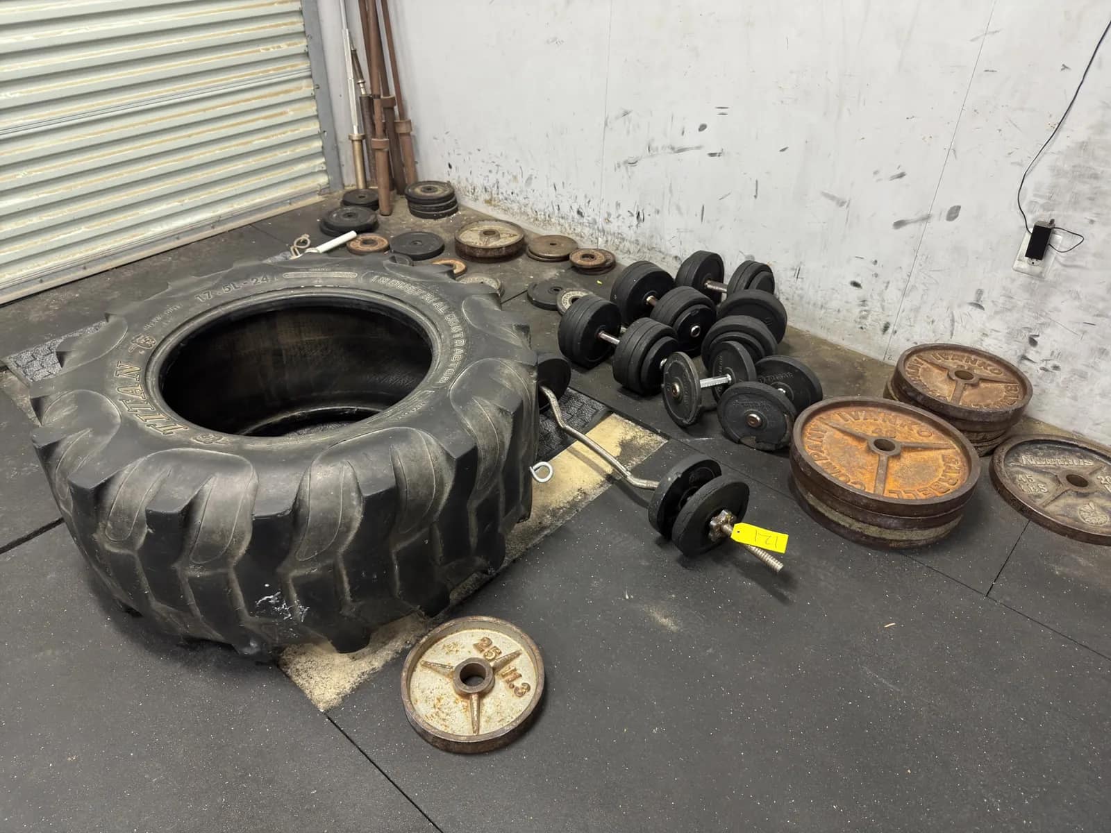assorted-metal-plate-weights-dumbbells-and-tire-9ac124