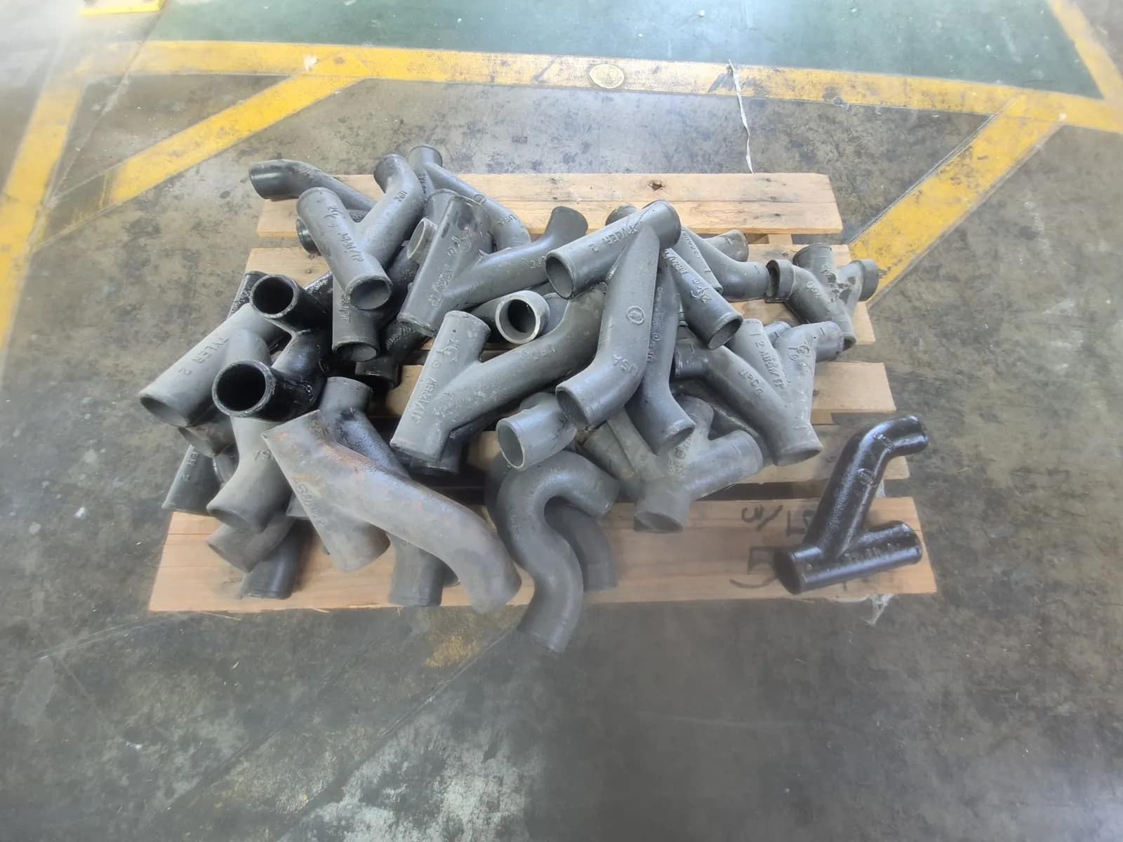 contents-of-pallet-assortment-of-cast-iron-multi-way-tubular-casting-likely-a-y-splitter-or-connector-fitting-for-fluid-air-or-exhaust-routing-no-hub-sanitary-double-wye-or-double-combination-wye-no-hub-sanitary-combination-wye-and-1-8-bend-often-called-a-combo-474b06
